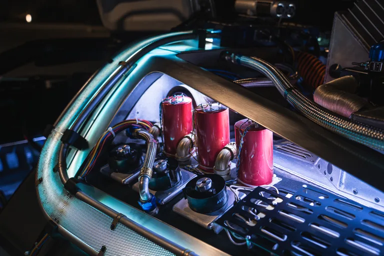 Engine bay detail with red capacitor cylinders and blue glowing fuel cells — DeLorean Time Machine