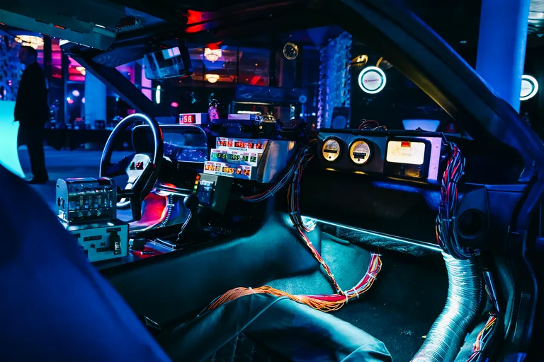 DeLorean Time Machine cockpit at an event — view through the windshield with time circuits glowing