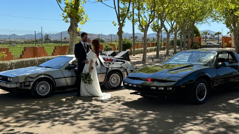 Rent the DeLorean Time Machine and KITT together for weddings — bride and groom between the two movie cars
