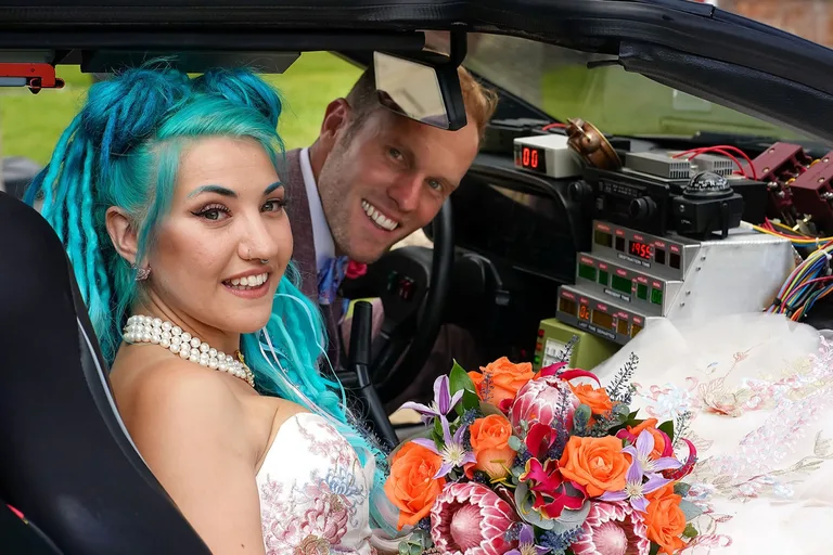 DeLorean Time Machine wedding car hire in Spain — newly-weds embracing in front of the car